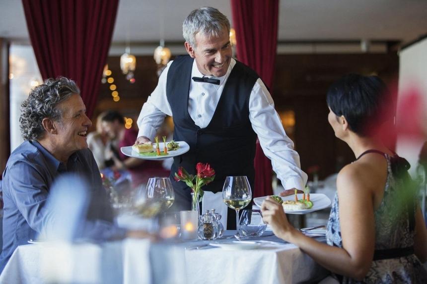 Waiter serves food for customers