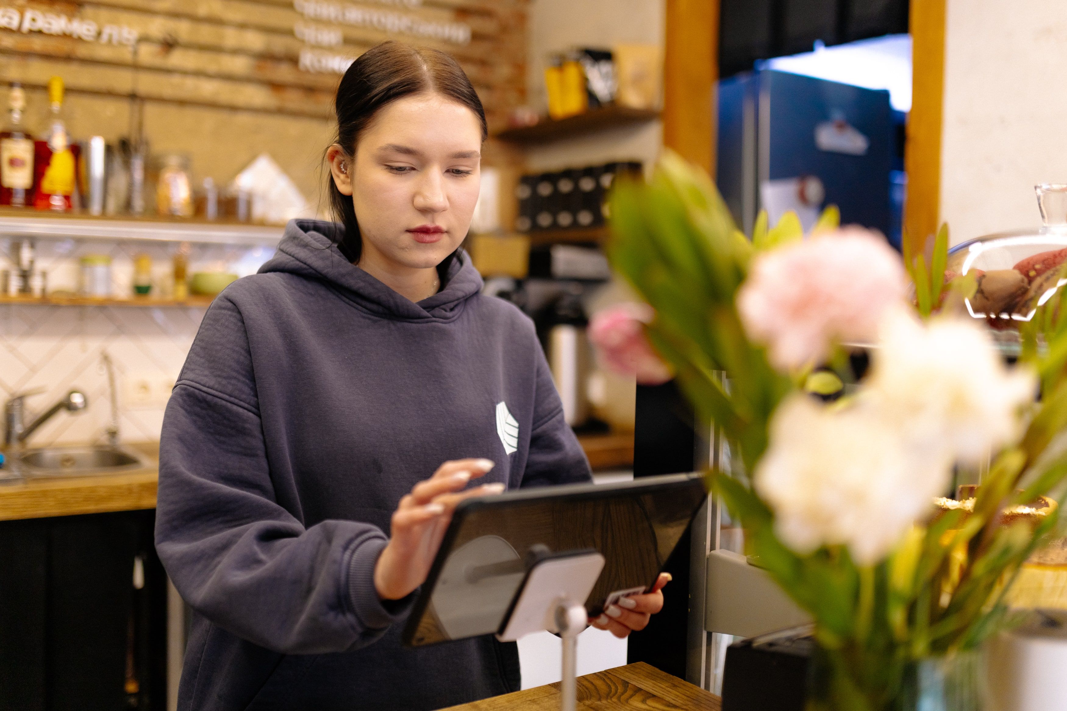 Кассир оформляет заказ на планшете с POS-системой в кофейне