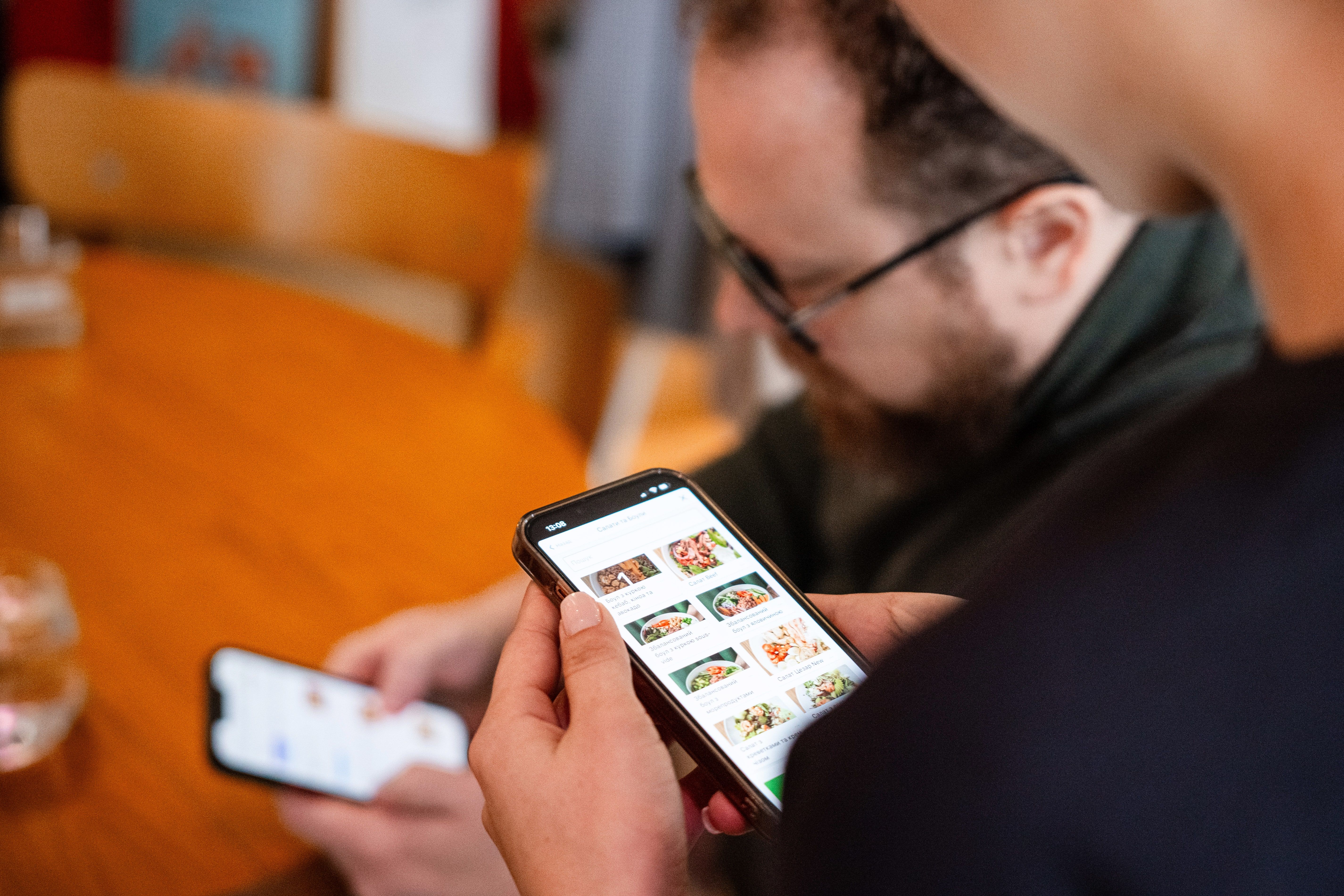 Гість оплачує замовлення по QR-коду на касі кавʼярні