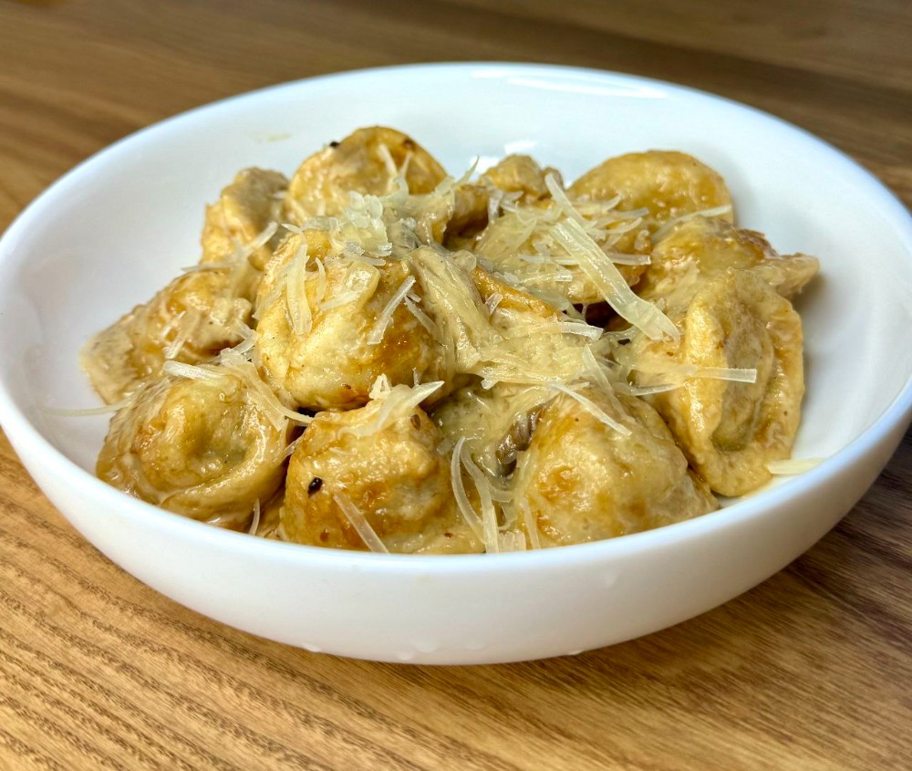 Пельмені смажені зі свининою в соусі з білих грибів